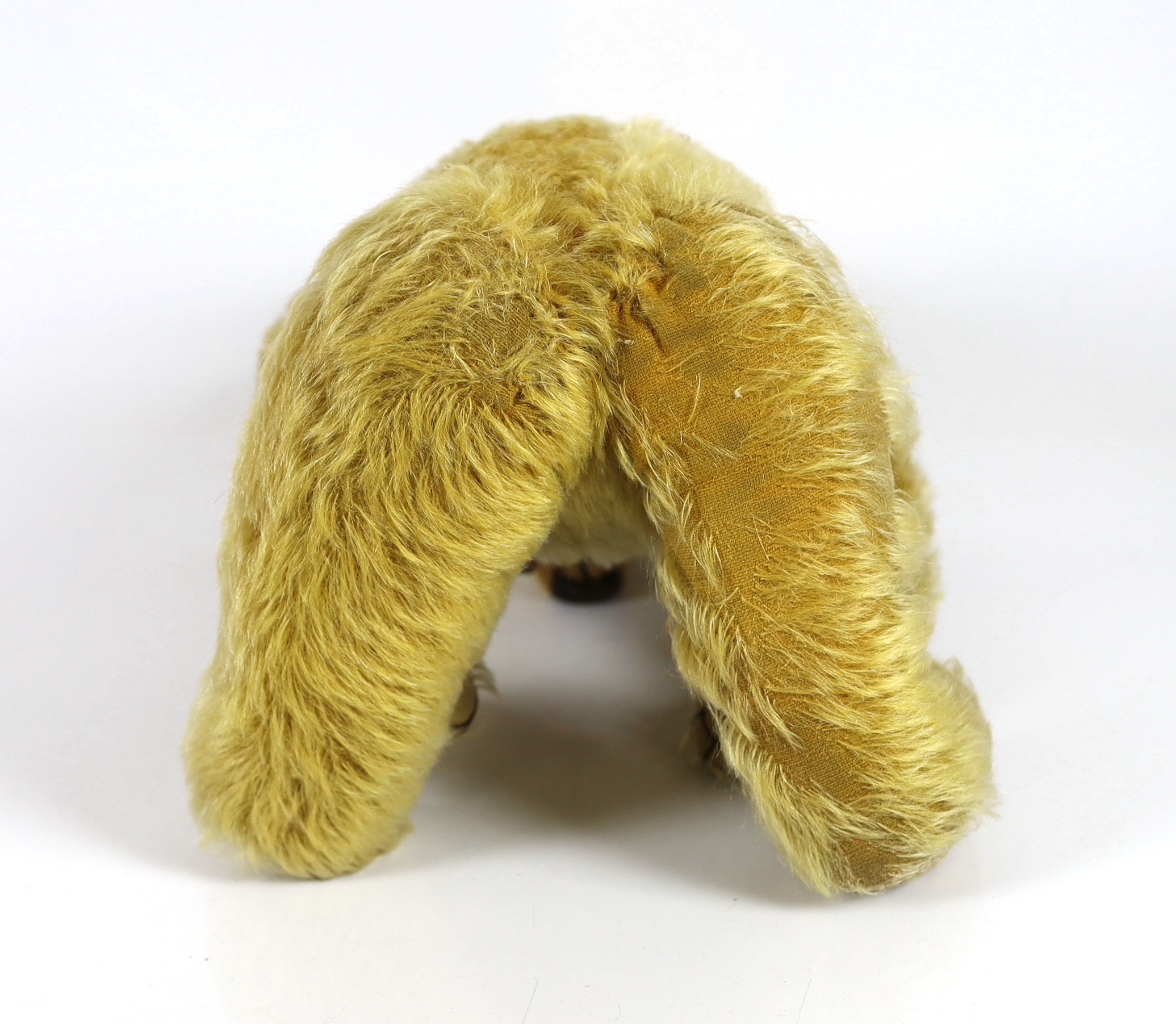 A 1930's Merrythought bear, with label, 44cm, old repair to foot, some hair loss